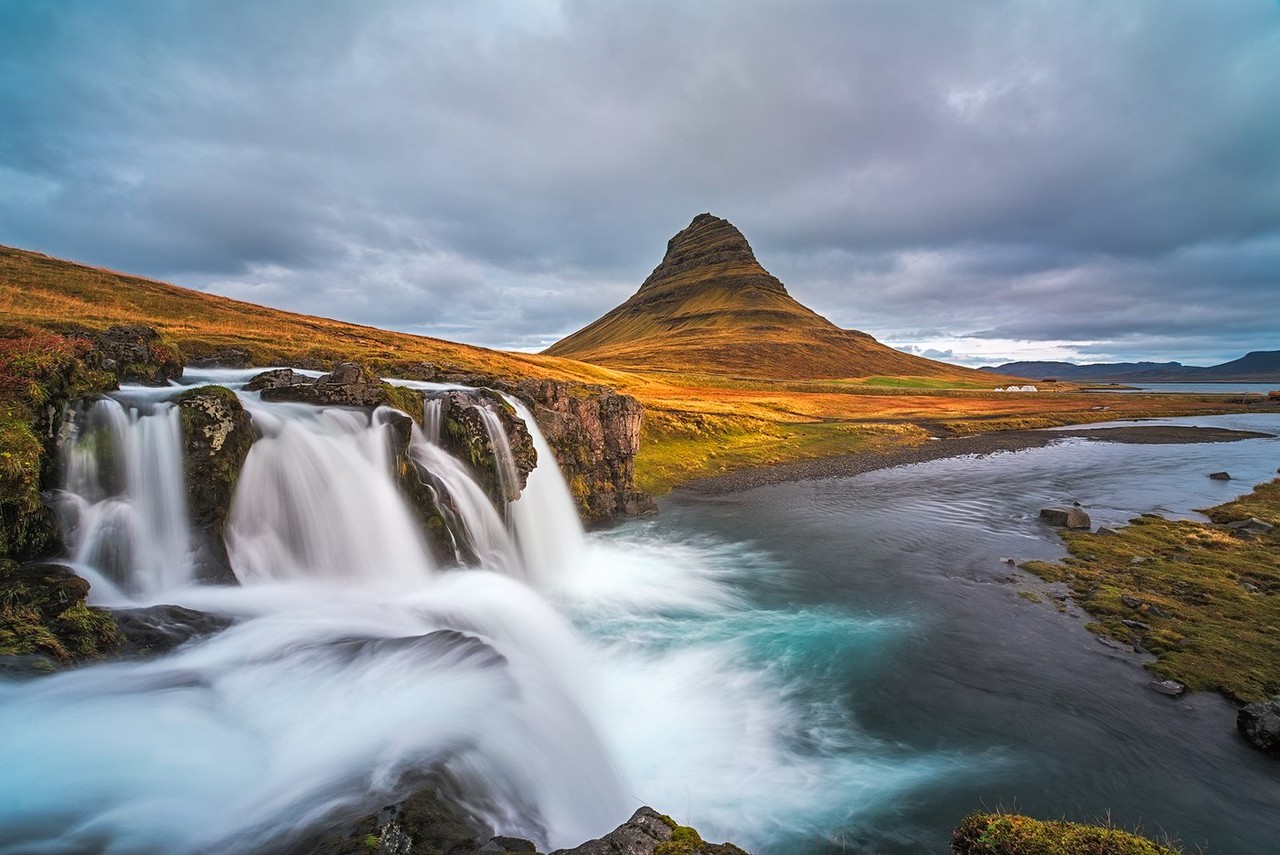 Water flows over a rocky waterfall beneath the peak of Kirkjufell.